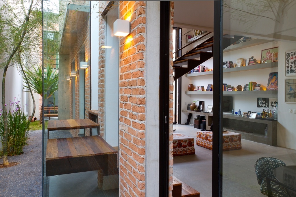 A escada de acesso ao pavimento superior é um dos destaques da Casa Urbana, projetada pela arquiteta Paula Bittar. Para não ocupar espaço no living e permitir que as pessoas passassem por baixo da estrutura, a profissional colocou o patamar para fora da casa, envolto por uma caixa de vidro (à esq.). A estrutura da escada mescla as madeiras de demolição peroba e canela - Sergio Scripilliti/ Divulgação