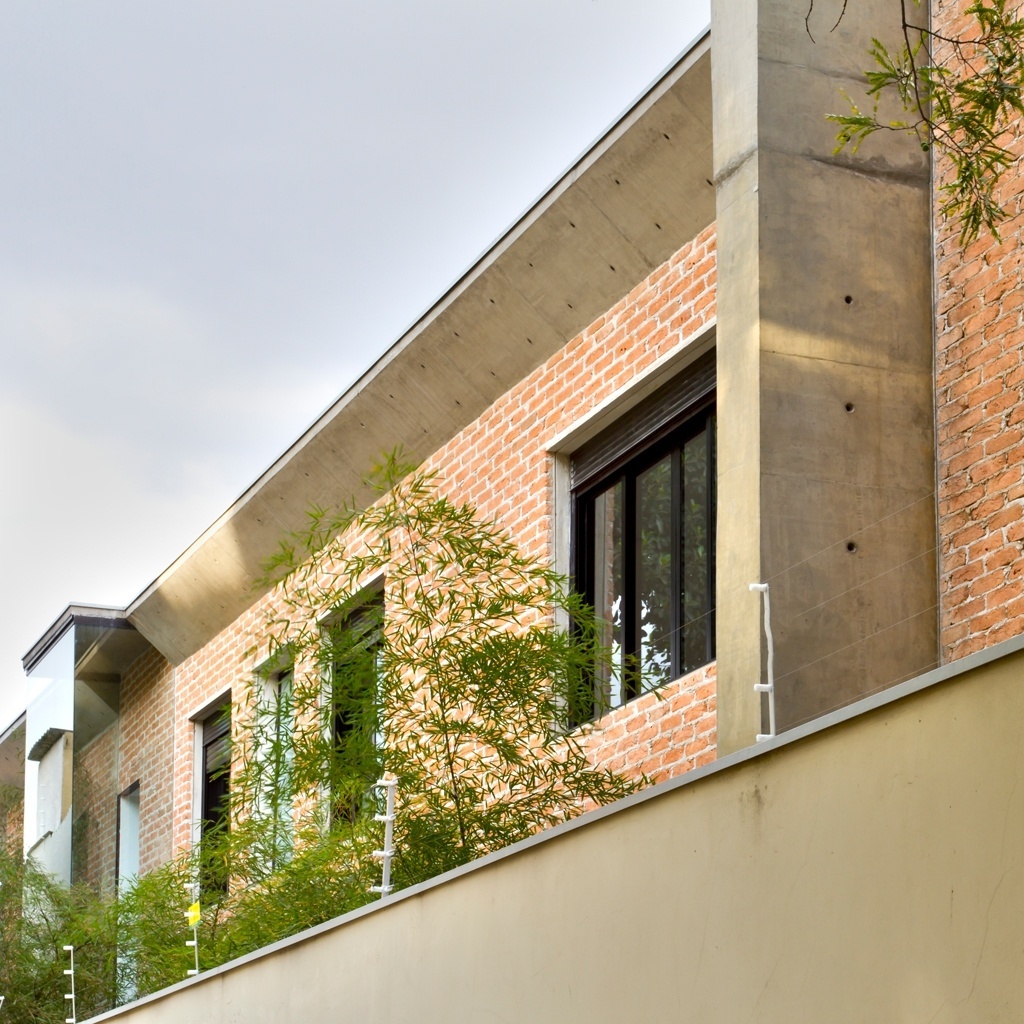 Na fachada lateral, o concreto deixado aparente recebeu tratamento com resina protetora e garante o ar de modernidade à construção. Para quebrar o aspecto rígido do material, a arquiteta Paula Bittar - autora do projeto da Casa Urbana - empregou tijolos de demolição nas paredes. As aberturas do pavimento superior asseguram iluminação farta à área íntima da residência - Sergio Scripilliti/ Divulgação