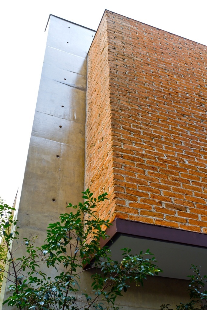 O pilar estrutural em concreto com tratamento resinado contrasta com os tijolos de demolição da parede envoltória do terraço que tem base em perfil de ferro galvanizado com pintura em tinta esmalte na cor café. A Casa Urbana, em São Paulo, foi projetada pela arquiteta Paula Bittar - Sergio Scripilliti/ Divulgação
