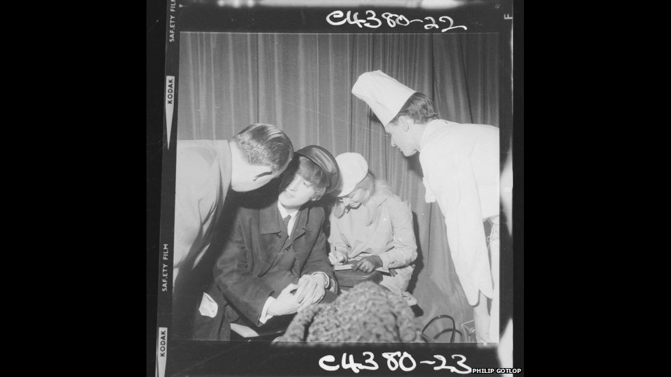 Uma "pequena fração? das milhares de fotografias de celebridades das décadas de 1960 e 1970 encontradas em um enorme baú, estão à venda. Imagens dos Beatles em situações informais - como esta deles dando autógrafos para a tripulação de um voo da Pan Am na sala de embarque - estão entre negativos e slides herdados por um parente da viúva do fotógrafo Philip Gotlop. O leiloeiro Richard Edwards disse que haviam "milhares de negativos como este." - BBC