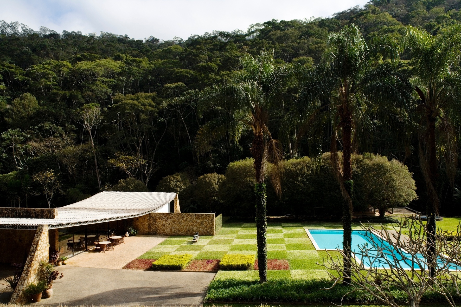 Casa Edmundo Cavanelas, em Pedro do Rio (RJ), projetada por Oscar Niemeyer. A obra, datada de 1954, tem paisagismo criado por Roberto Burle Marx, no qual se destaca o xadrez de gramíneas. O local foi uma das locações do filme "Flores Raras", do cineasta Bruno Barreto, que conta a história do romance entre a escritora americana Elizabeth Bishop (1911-1979) e Lota Macedo Soares, paisagista e urbanista autodidata brasileira - Leonardo Finotti/ UOL