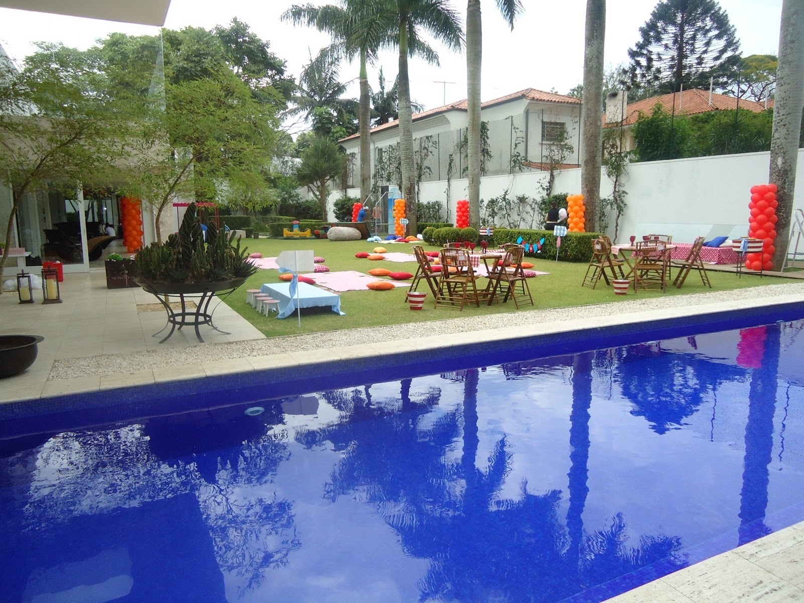 Para essa festa, cujo tema era piquenique, a decoradora Cristiana Prado, da Moge Mug, espalhou almofadas pelo jardim da casa - Divulgação