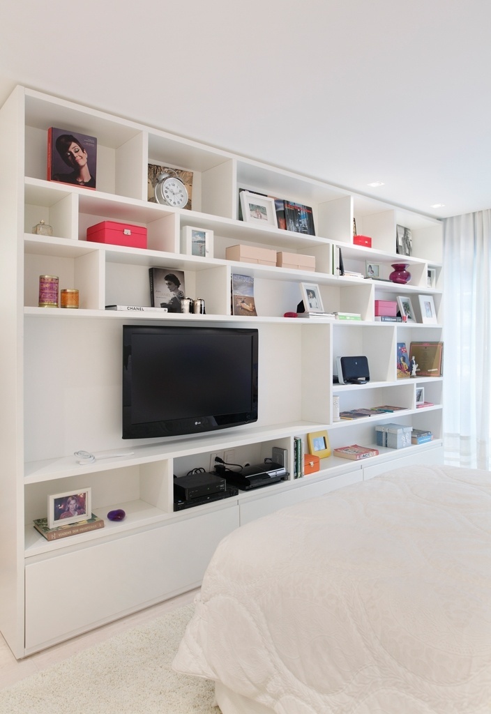 Os objetos coloridos destacam-se nos nichos da marcenaria branca, executada pela CA e idealizada pela arquiteta Izabella Lessa. O trabalho em matelassê da colcha quebra com a homogeneidade do tom do tecido - Denílson Machado/ MCA Estúdio/ Divulgação