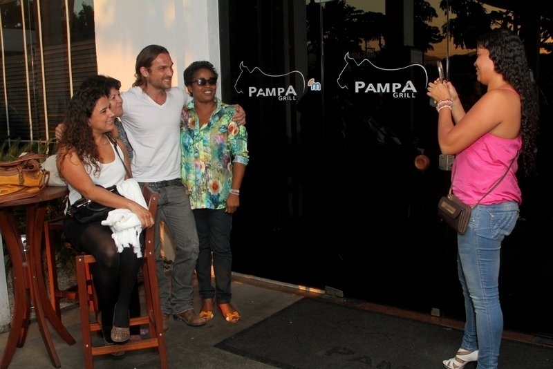 13.set.2013 - Igor Rickli se reúne com o elenco de "Flor do Caribe", em uma churrascaria no Rio de Janeiro, para assistir ao último capítulo da trama. Ele parou para tirar foto com fãs que estavam no local