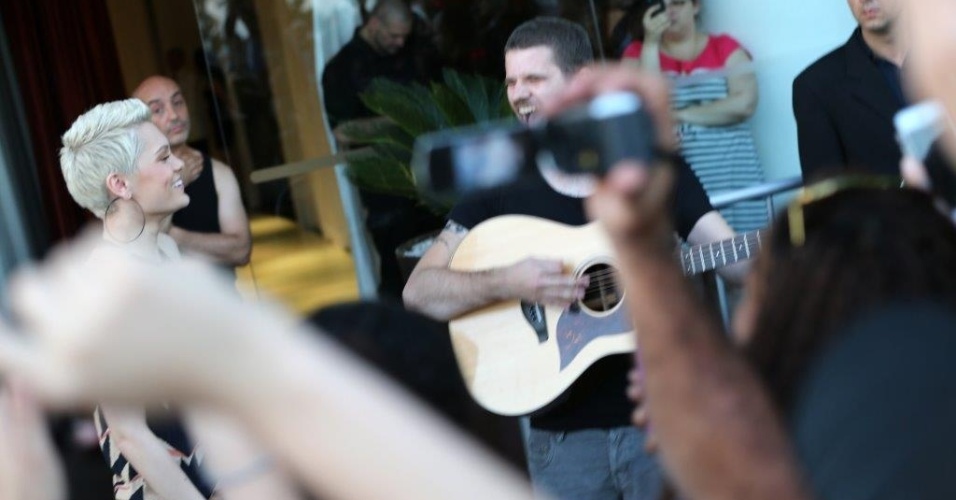 14.set.2013 - Acompanhada de um integrante de sua banda, Jessie J canta a música "Do It Like a Dude" para os fãs que aguardavam na saída do hotel Fasano, em Ipanema
