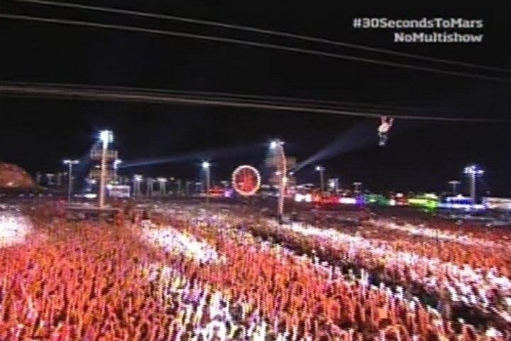 14.set.2013 - Depois de tocar em uma plataforma, o vocalista Jared Leto do Thirty Seconds to Mars passa sobre a platéia em uma tirolesa