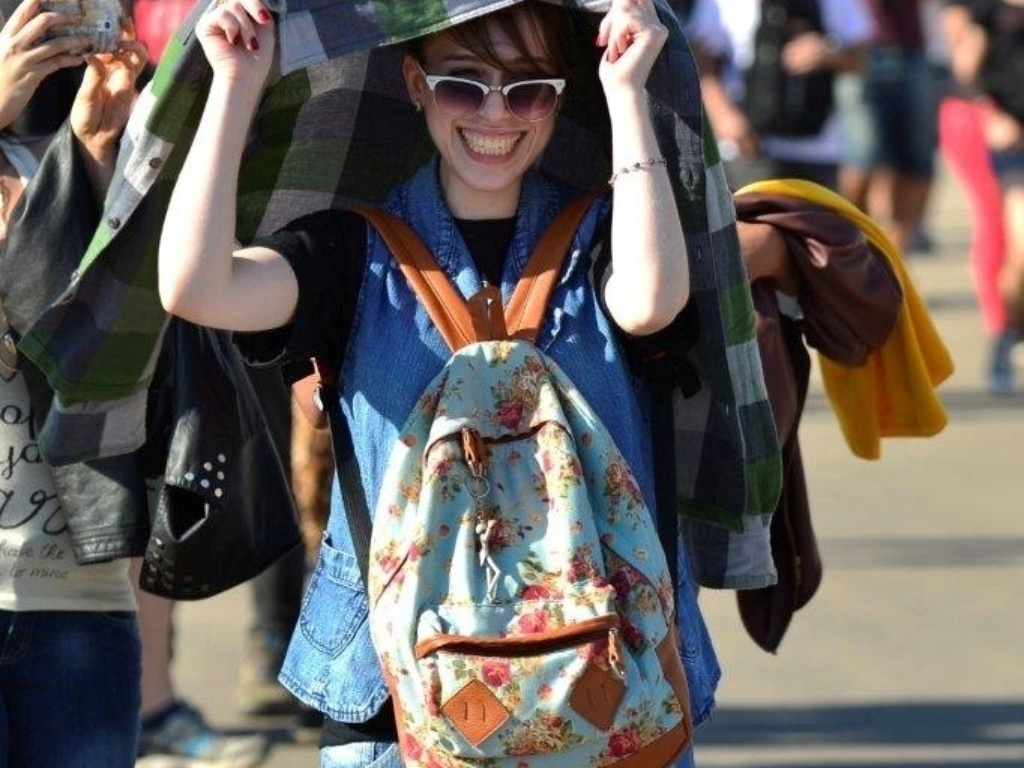 14.set.2013 - No segundo dia de evento, jovem se protege do forte sol na Cidade do Rock - Andre Muzell / AgNews