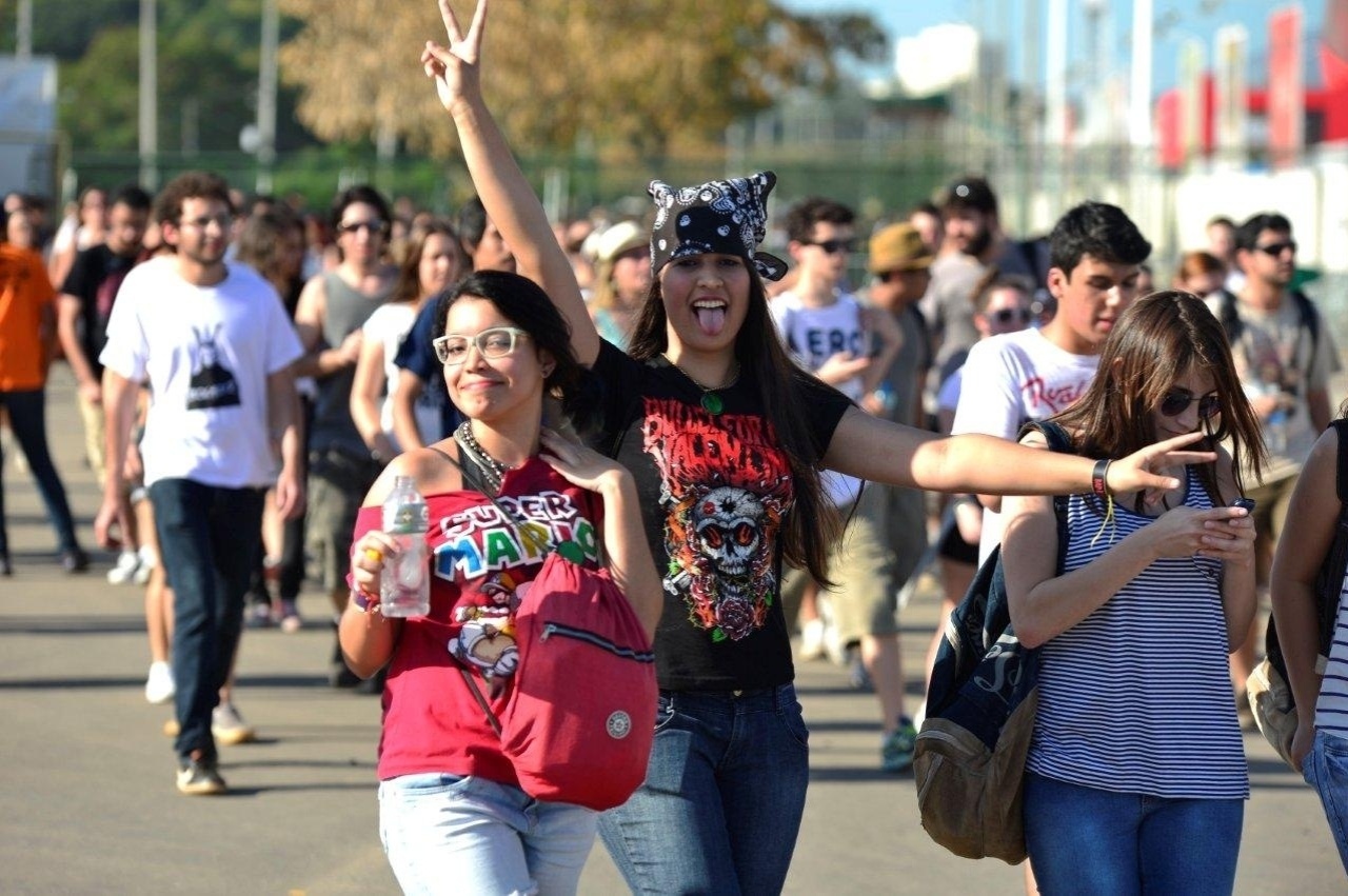 14.set.2013 - Para se refrescar, jovem bebe água para enfrentar o forte sol na Cidade do Rock - Andre Muzell / AgNews