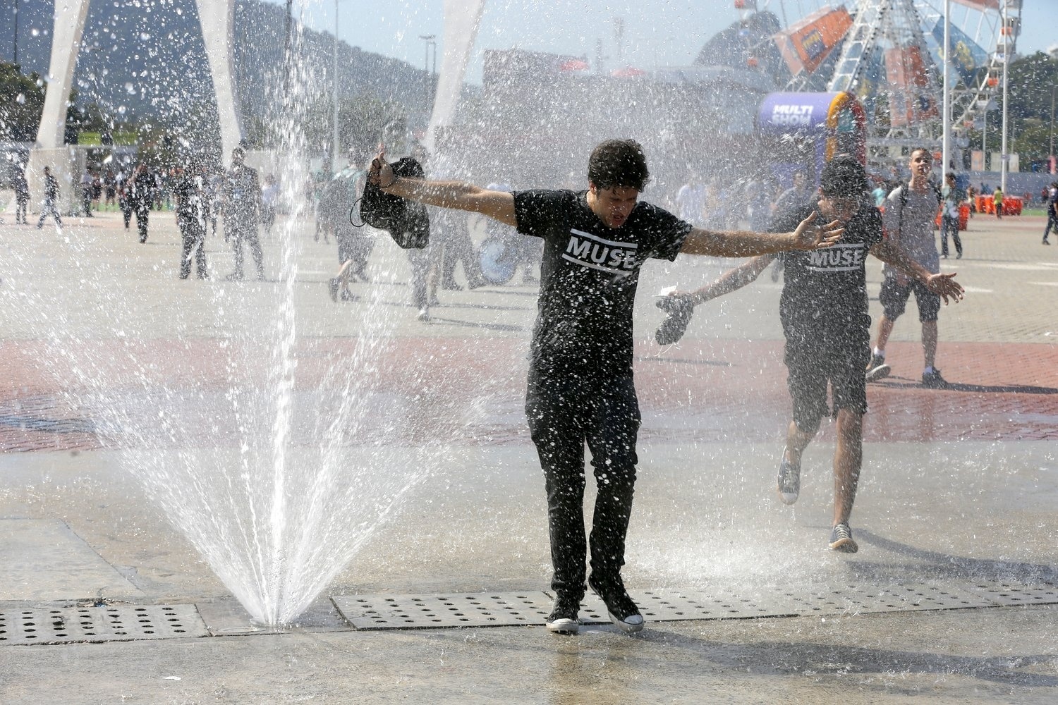 14.set.2013- Debaixo de forte sol, jovens se refrescam em chafariz  da Cidade do Rock - Felipe Panfili/AgNews