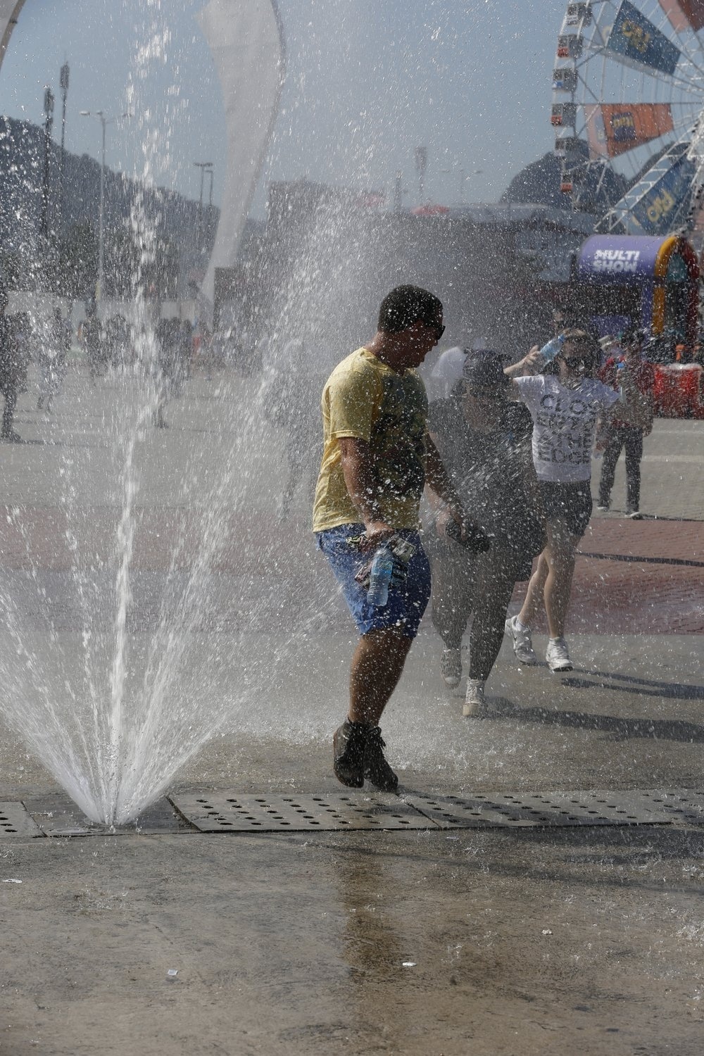 14.set.2013- Debaixo de forte sol, jovens se refrescam em chafariz  da Cidade do Rock - Felipe Panfili/AgNews