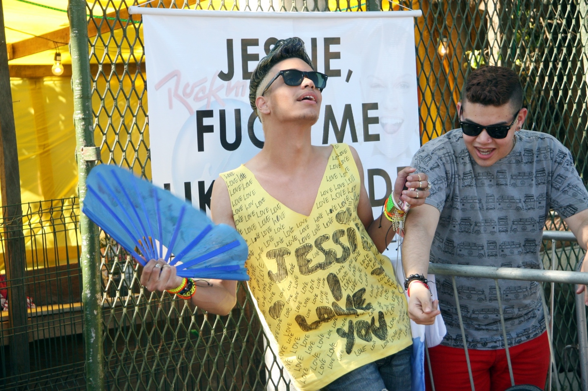 15.set.2013 - O estudante Raí Paulo da Gama, de 20 anos, faz pose ao lado de cartaz para Jessie J na fila do Rock in Rio, com Matheus Barreto mostrando sua camiseta personalidada em homenagem à cantora - Zulmair Rocha/UOL