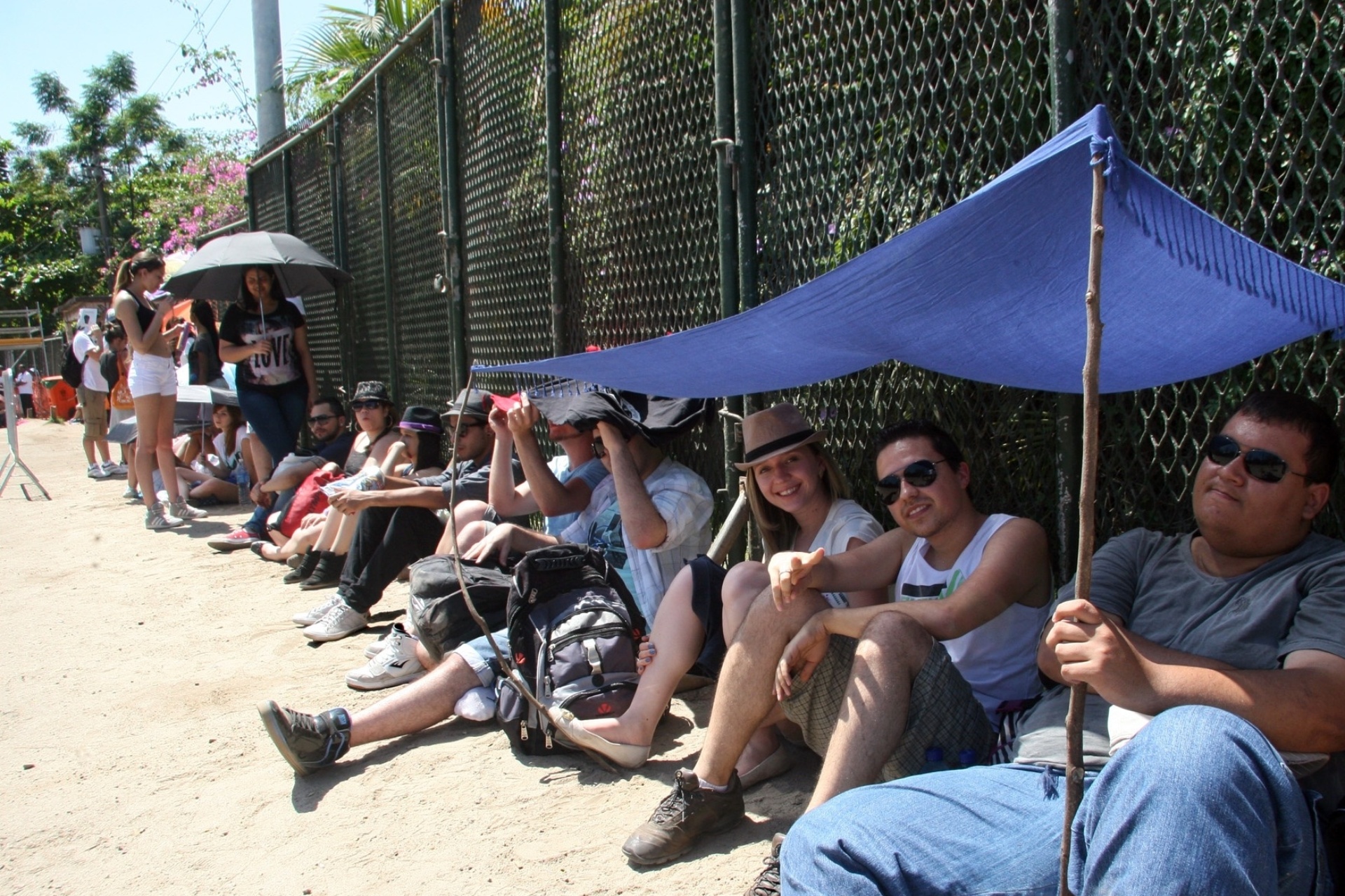 15.set.2013- Grupo improvisa barraca para se proteger do forte sol na fila do Rock in Rio - Zulmair Rocha/UOL