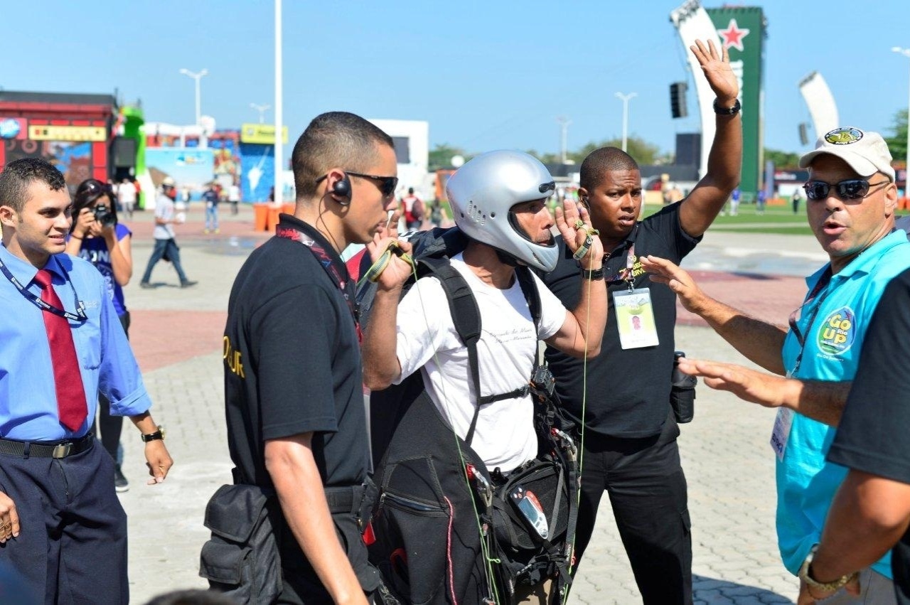 15.set.2013- Seguranças abordam piloto de parapente que causou tumulto ao pousar na Cidade do Rock, neste domingo, 15 - Andre Muzell / AgNews