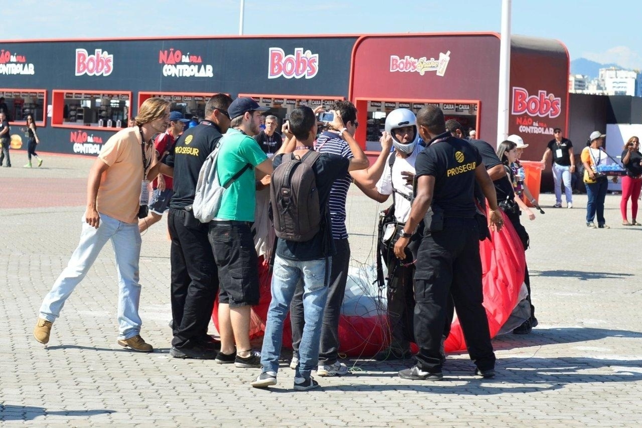 15.set.2013- Seguranças abordam piloto de parapente que causou tumulto ao pousar na Cidade do Rock, neste domingo, 15 - Andre Muzell / AgNews