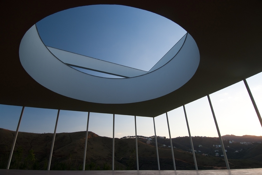 O bloco triangular tem recorte circunscrito que leva luz natural à varanda frontal da Casa Galeria. A ideia cria um jogo lúdico de sobreposições geométricas que compõem a arquitetura pensada por Fernando Maculan e Mariza Machado Coelho. A estrutura escultural constrói o conceito de um espaço híbrido "museu-residência" em Minas Gerais - Fábio Del Re & Carlos Stein/ Divulgação