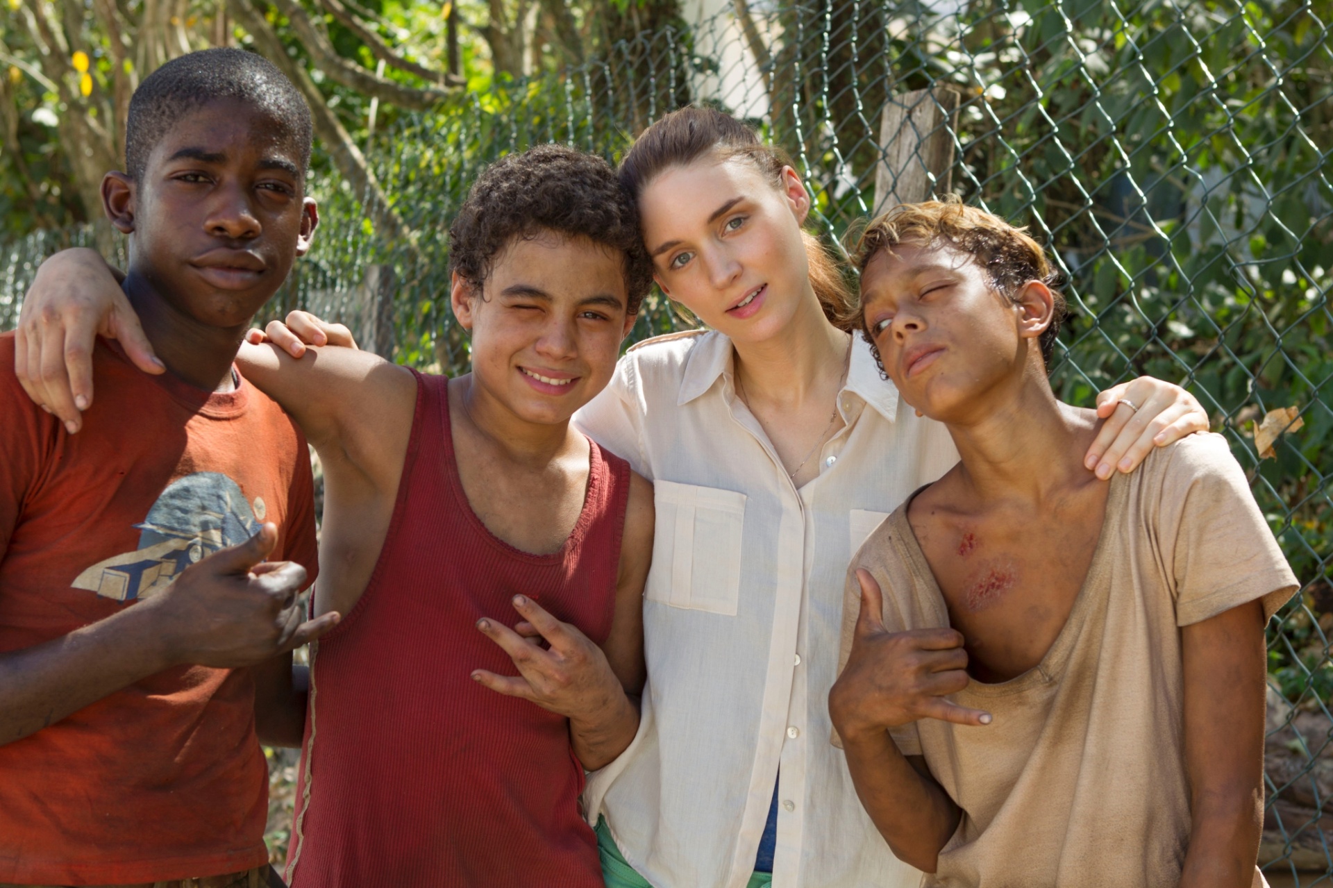 Rooney Mara com meninos que interpretam Raphael, Gardo e Rato no filme "Trash".  O longa é um thriller contemporâneo que acompanha três garotos que vivem num lixão - Daniel Behr/Divulgação