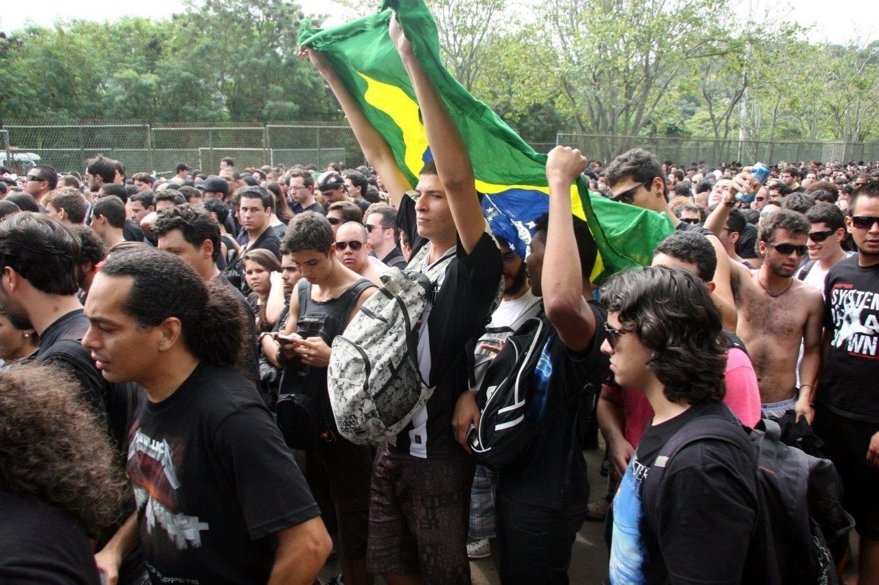19.set.2013 - Rapazes seguram bandeira do Brasil na fila para o primeiro dia de shows da segunda semana de Rock in Rio - Zulmair Rocha/UOL