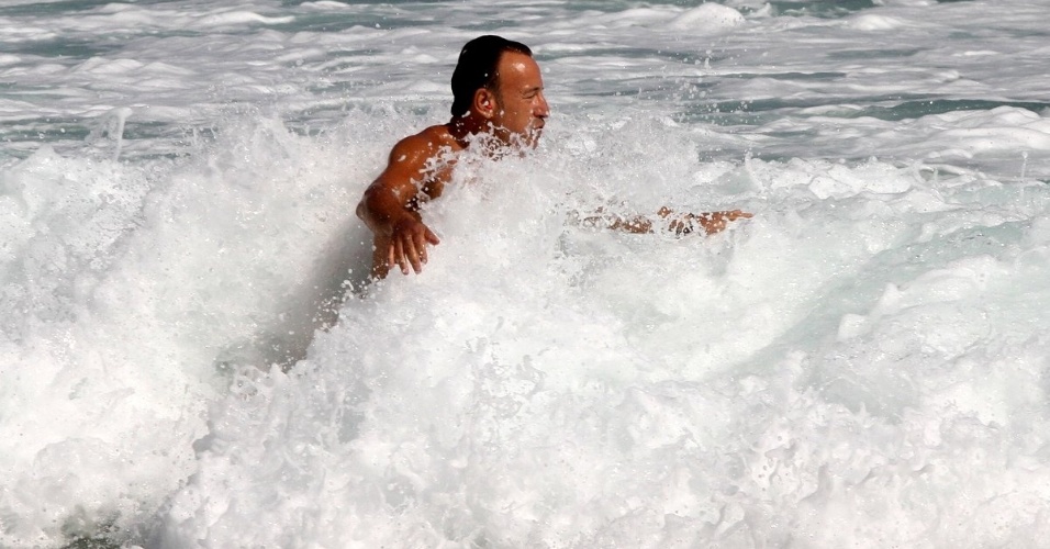 20.set.2013 - Bruce Springsteen mergulha na praia da Barra, na zona oeste do Rio. Atração do Rock in Rio, o cantor é o último a se apresentar no Palco Mundo neste sábado (21)
