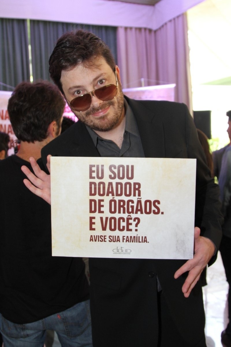 20.set.2013 - Danilo Gentili posa com cartaz da campanha de doação de órgãos