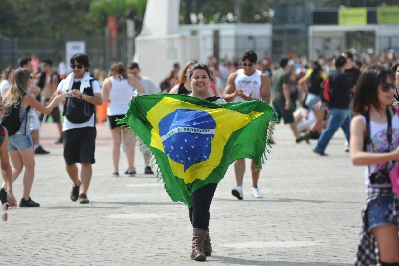 20.set.2013 - Fã abre bandeira do Brasil ao chegar na Cidade do Rock para o quinto dia de Rock in Rio - AgNews