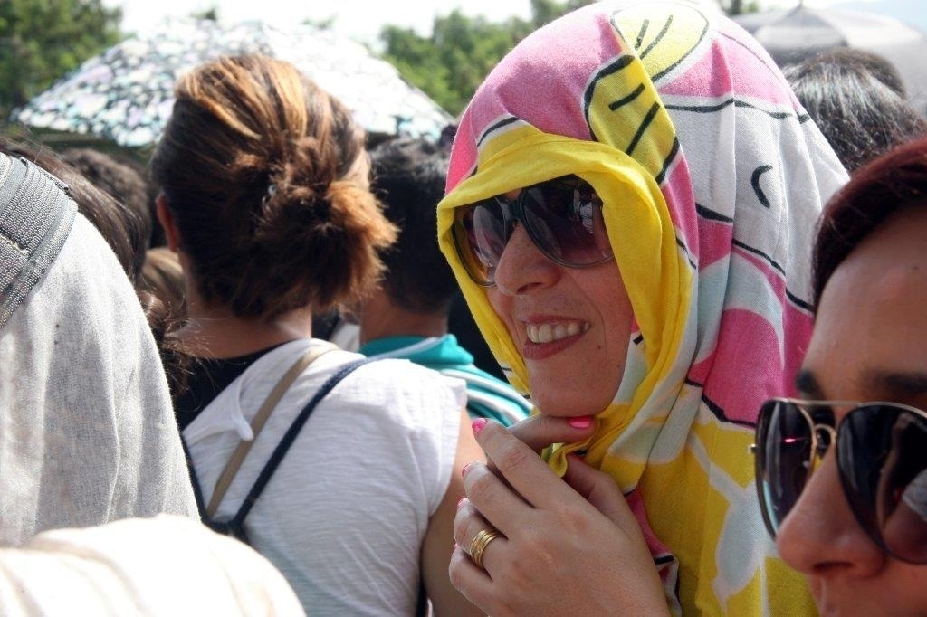 20.set.2013 - Fã se protege do sol enquanto espera a abertura dos portões da Cidade do Rock - Zulmair Rocha/UOL