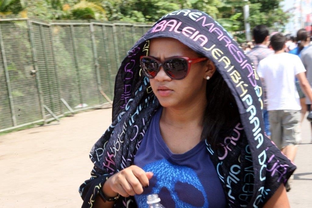 20.set.2013 - Fã se protege do sol enquanto espera a abertura dos portões da Cidade do Rock - Zulmair Rocha/UOL