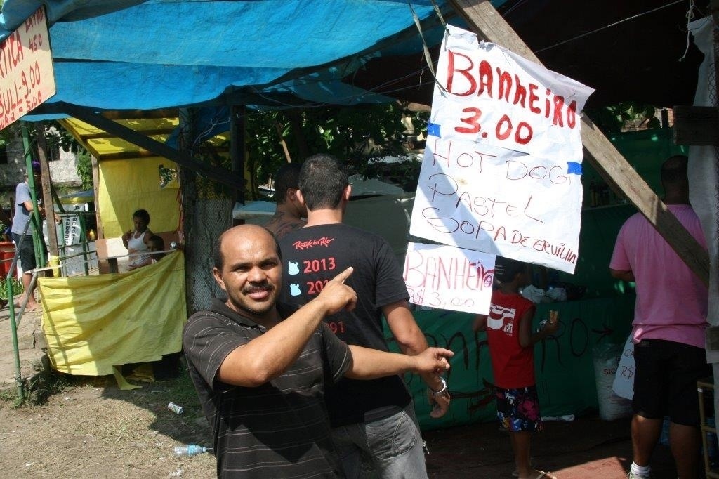 20.set.2013 - Homem anuncia banheiro a R$3,00 na fila do Rock in Rio - Zulmair Rocha/UOL