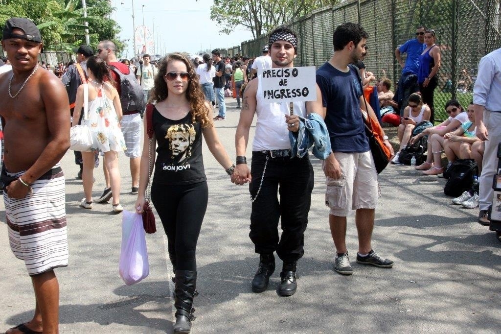 20.set.2013 - O carioca Gil Dias e a namorada usam placa para anunciar que procuram ingressos para esta sexta-feira, quando toca o Bon Jovi - Zulmair Rocha/UOL
