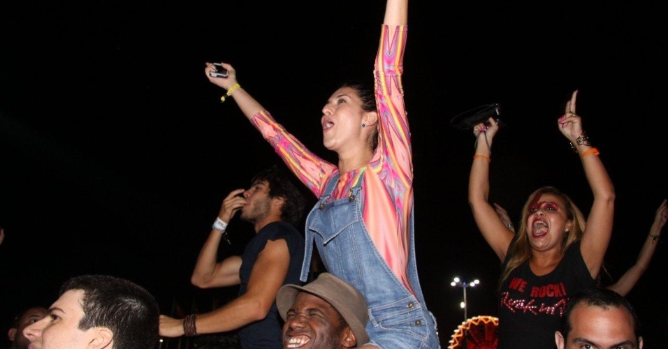 20.set.2013 - Fernanda Paes Leme sobe no ombro de um amigo durante o show do Bon Jovi