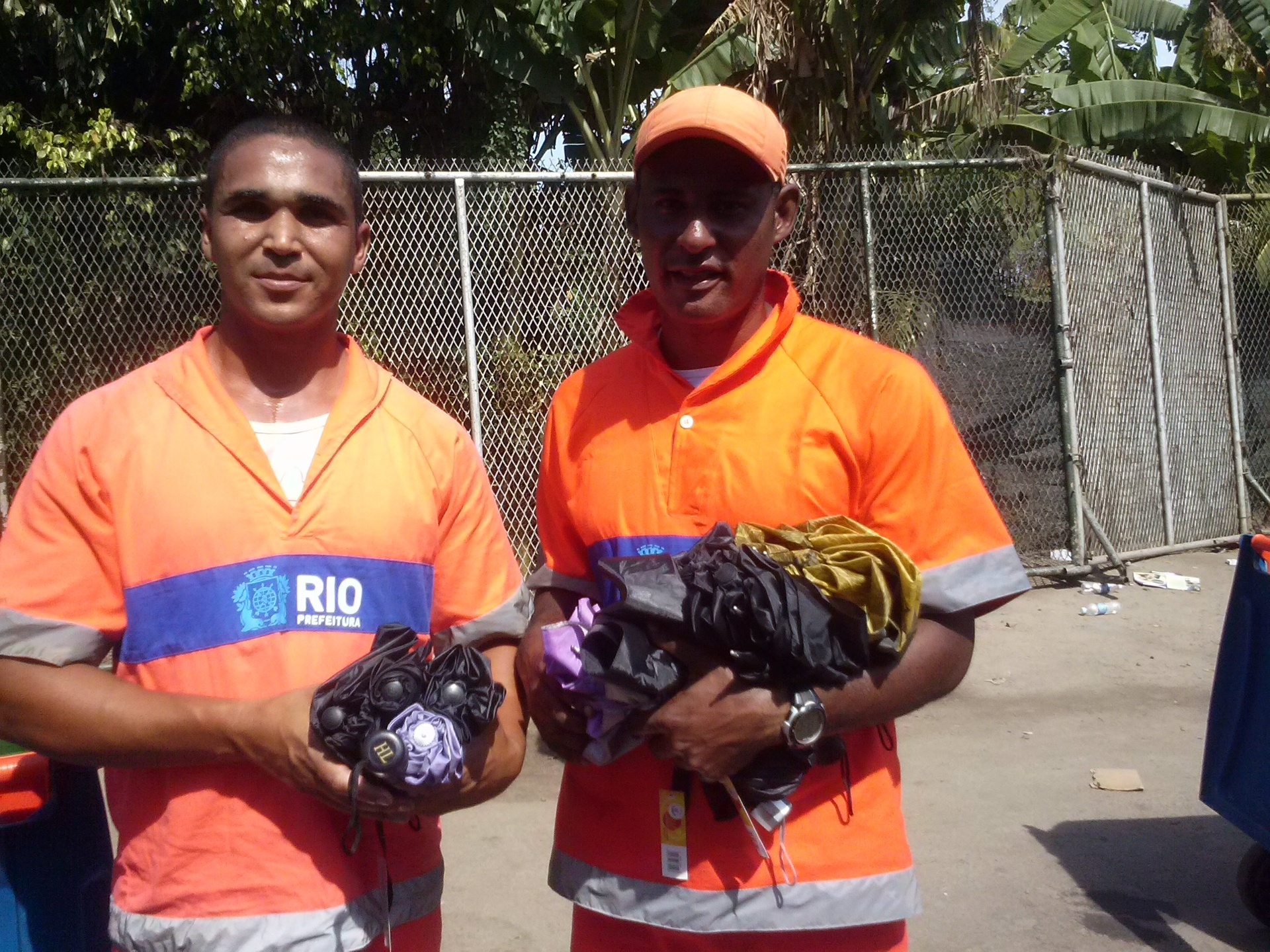 21.set.2013 - Os garis Márcio Santos e Márcio Rodrigues ganharam algumas sombrinhas dos jovens que entraram na Cidade do Rock, já que não é permitido a entrada do objeto no local - Marcela Ribeiro/UOL