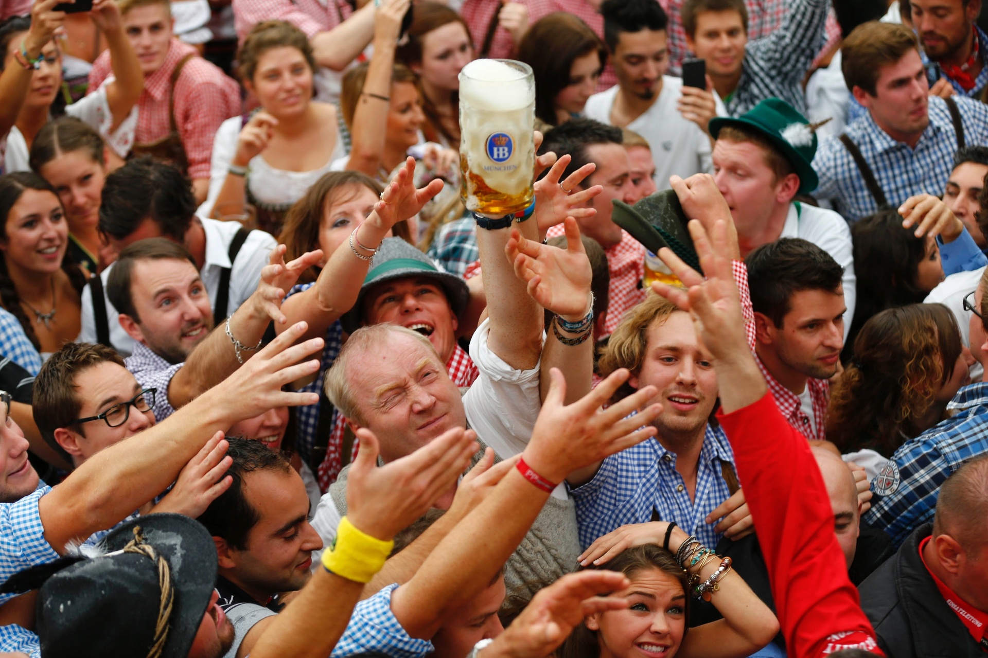 21.set.2013 - Visitantes tentam pegar primeira cerveja do primeiro barril durante a cerimônia de abertura do 180º Oktoberfest em Munique, na Alemanha - REUTERS/Michael Dalder