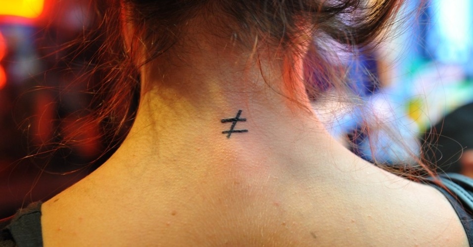 21.set.2013 - Thaila Ayala tatua o símbolo da diferença na nuca, durante o Rock in Rio