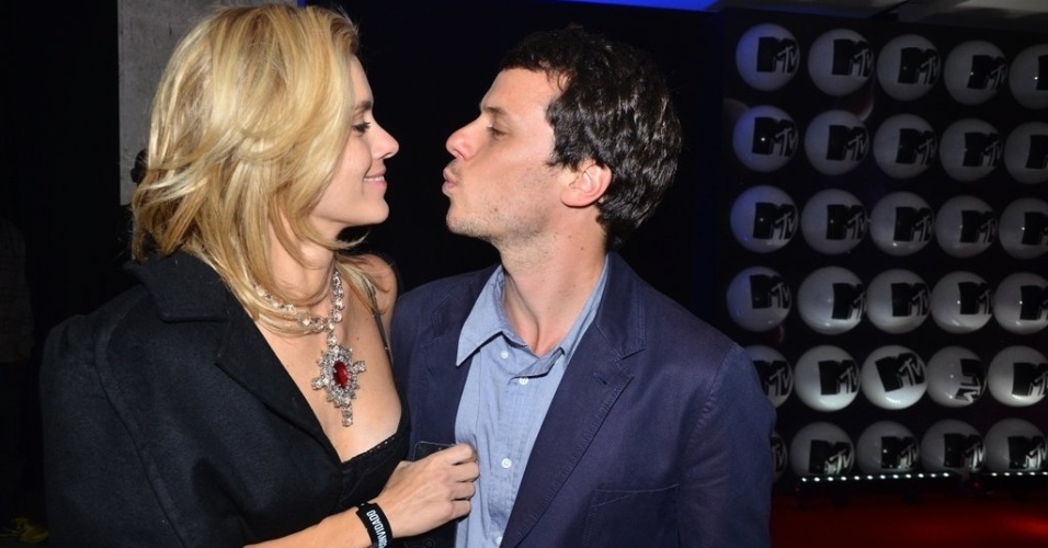 24.set.2013 - O diretor Tiago Worcman pede um beijo para a mulher, Carolina Dieckmann, na festa de lançamento da nova MTV, em São Paulo