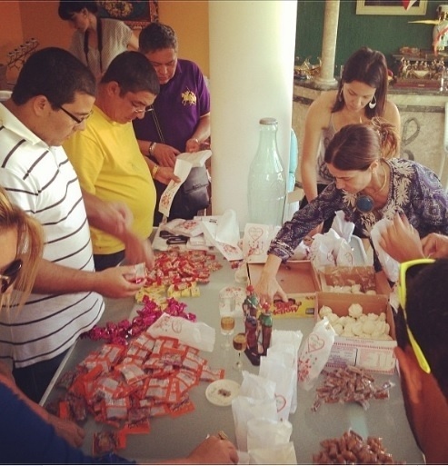 27.set.2013- Com a ajuda de amigos, Zeca Pagodinho monta saquinho com doces de São Cosme e Damião