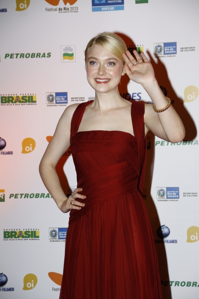 28.set.2013 -  Dakota Fanning acena para os paparazzi na première do filme "Night moves" no Festival do Rio