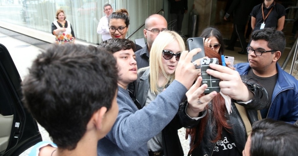 29.set.2013 - Antes de ir embora do Brasil, Dakota Fanning atende fãs na porta do hotel em que ficou hospedada na zona sul do Rio