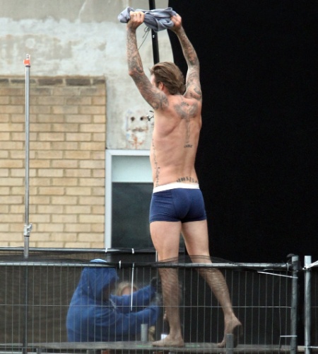 2.out.2013 - David Beckham fica só de cueca ao gravar um novo comercial para a marca H&M, que deve estrear em fevereiro de 2014. O ex-jogador, que continua em boa forma, aparece tirando a camisa, arrumando a cueca e correndo no telhado da cervejaria Old Trumam Brewery, em Brick Lane, Londres