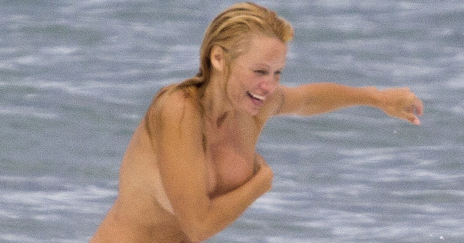 2.ou.2013 - De topless, Pamela Anderson curte praia em Biarritz, na França, com o namorado, o produtor Rick Solomon.