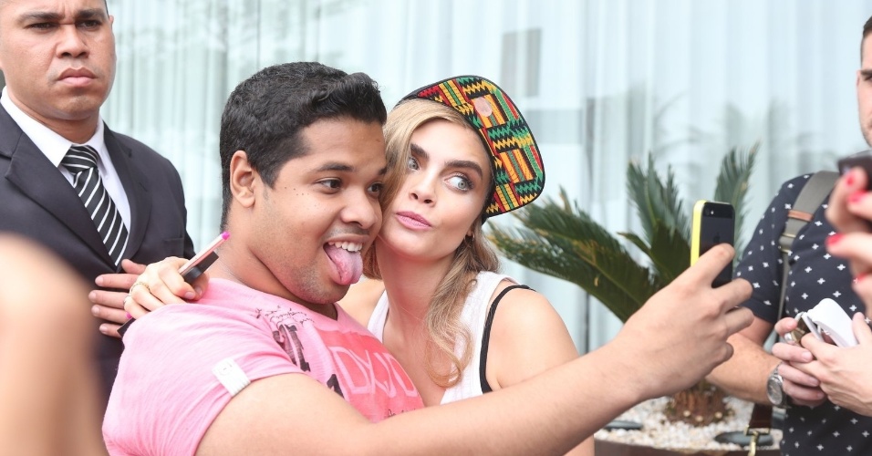 3.set.2013- Simpática, Cara fez caretas para fotos  com fãs na porta do hotel, na Zona Sul do Rio