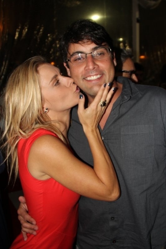 03.out.2013- Carolina Dieckmann beija o amigo Bruno de Luca na pré-estreia do filme "Entre Nós", no Rio