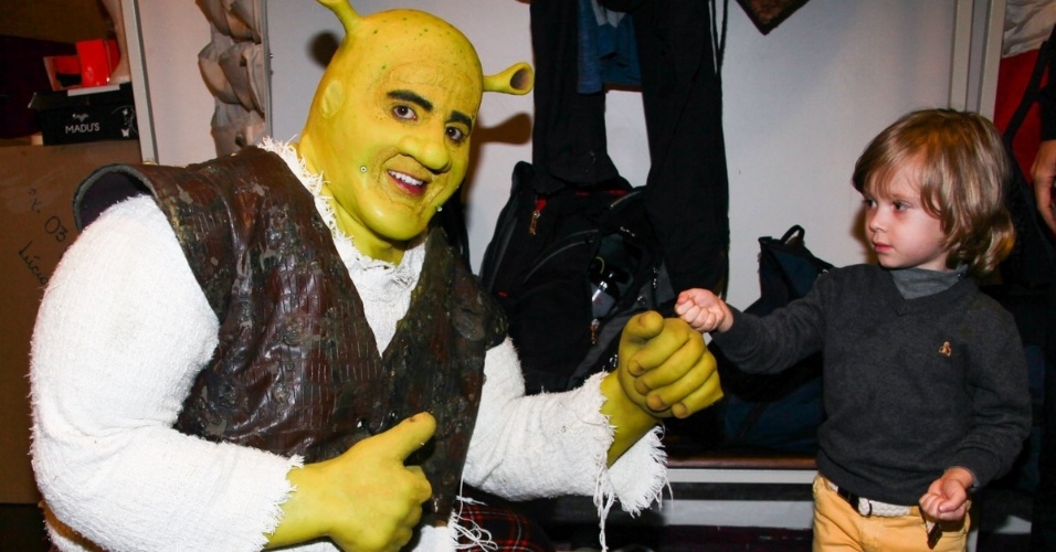 6.out.2013 - A apresentadora Adriane Galisteu apresenta o personagem Shrek ao filho Vittorio nos camarins do espetáculo em São Paulo