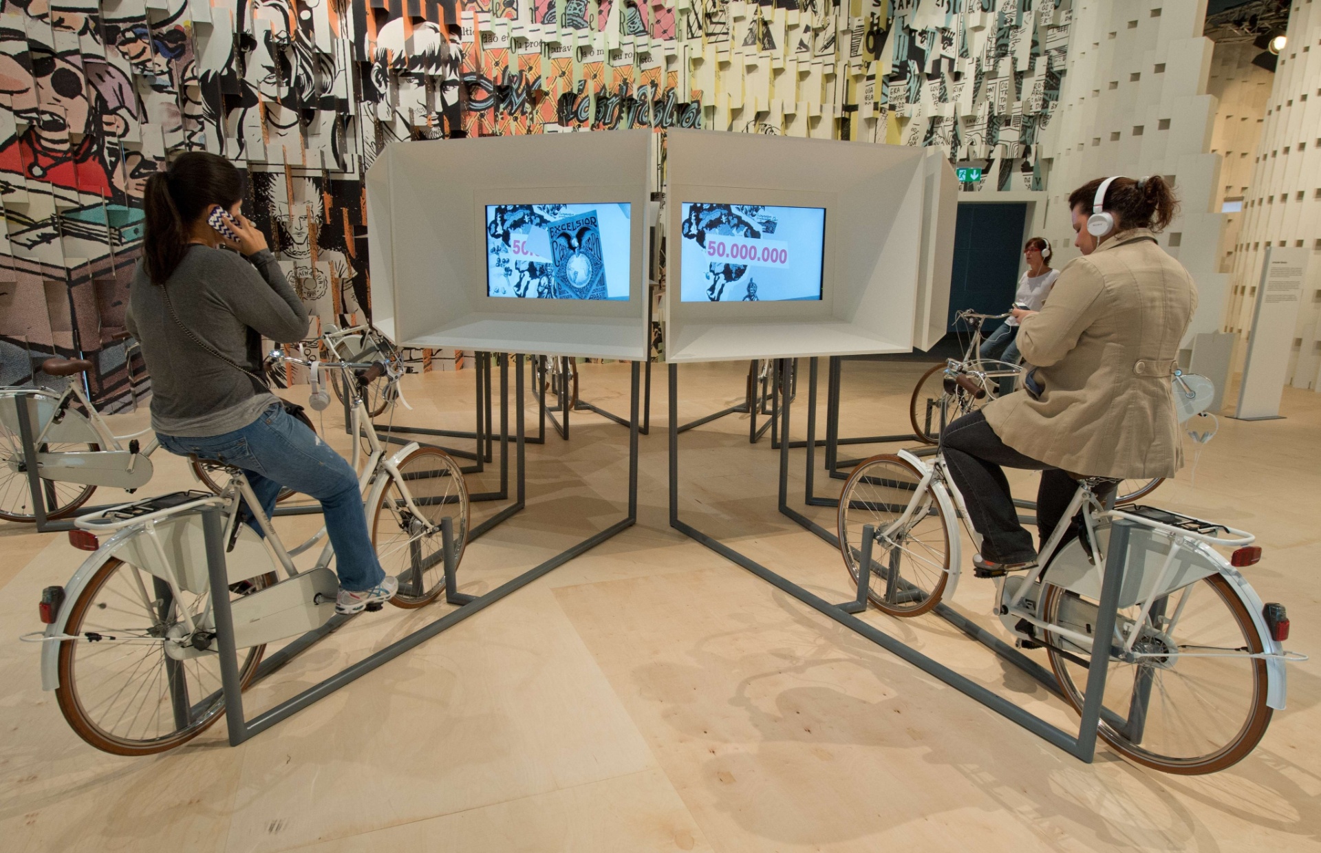 8.out.2013 - Pessoas usam bicicletas como gerador de energia para assistir vídeos sobre literatura brasileira na Feira Literária de Frankfurt 2013, na Alemanha - AFP PHOTO / DPA / BORIS ROESSLER