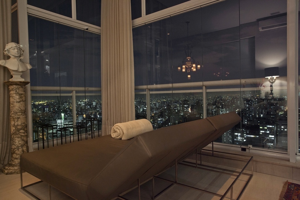 As janelas envidraçadas possibilitam a contemplação da linda visão de São Paulo, seus arranha-céus e suas luzes. A varanda envidraçada foi concebida para ser um recanto relaxante, especialmente criado para apreciar a paisagem. O projeto de reforma leva a assinatura do designer de interiores Oscar Mikail - Thiago Travesso/ Divulgação