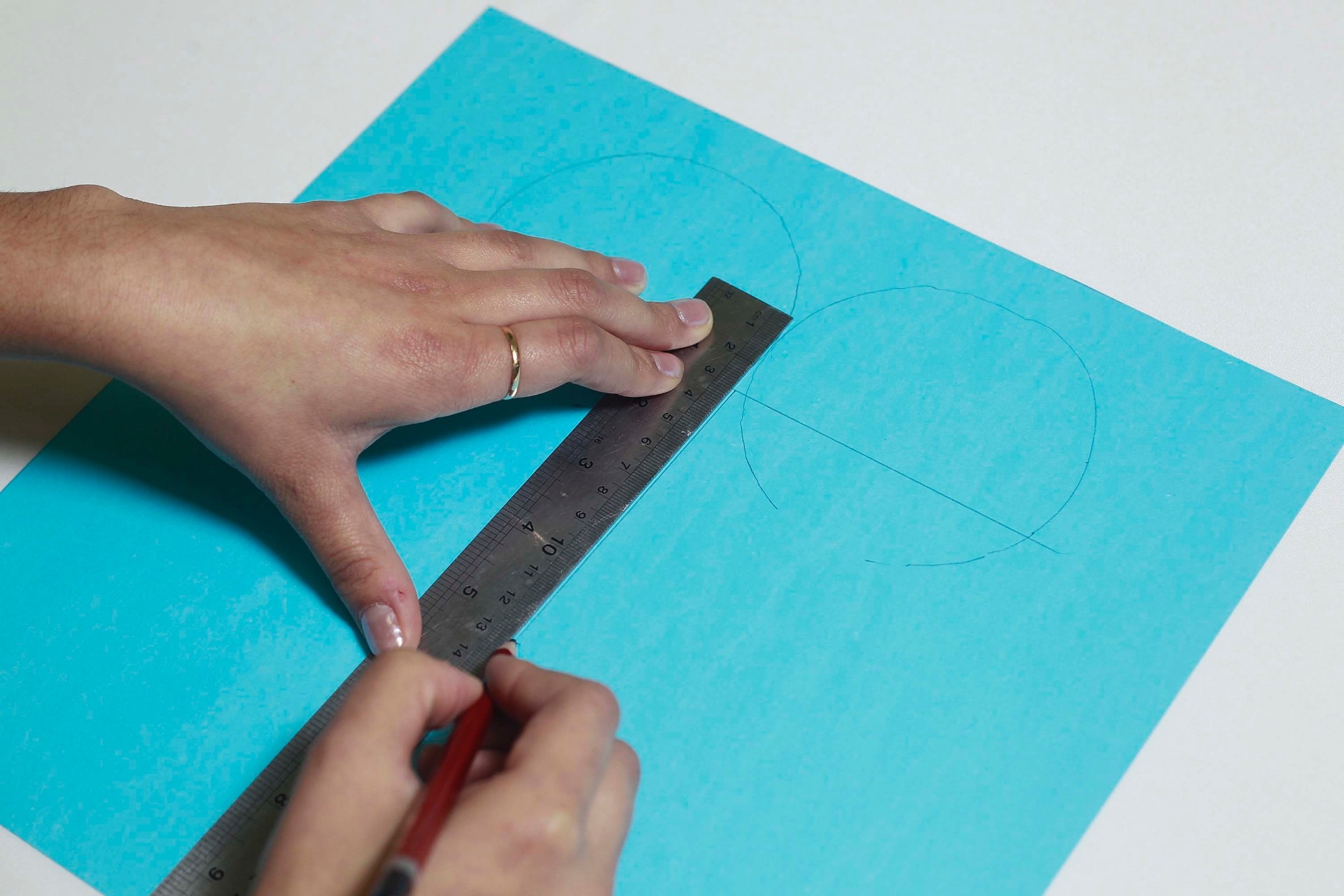 Para continuar a preparação do molde para o moletom, posicione a régua na vertical, bem no ponto em que os círculos se tocam, e faça um traço de dez centímetros para baixo - Reinaldo Canato/UOL