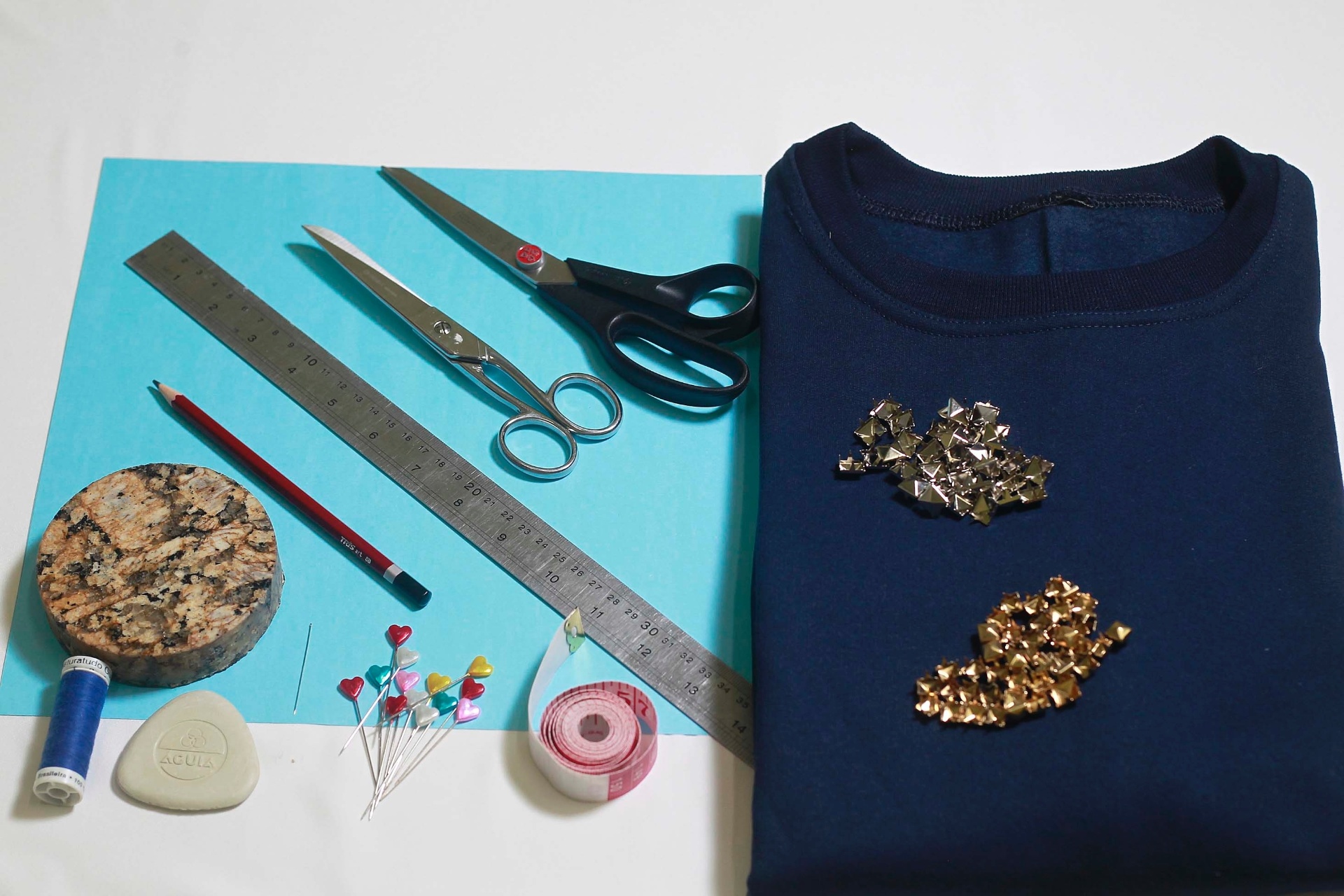 Para personalizar o moletom, você vai precisar de: uma blusa feita do tecido e sem estampa, folha de papel cartão (30 cm x 30 cm), lápis, tesoura para papel, tesoura para tecido, 70 tachinhas ou rebites prateados e dourados em, pelo menos, dois tamanhos diferentes, giz de alfaiate, agulha de mão, linha de algodão ou poliéster da cor da blusa, dois alfinetes, régua, fita métrica e peso para papel em formato circular, com mais ou menos 10 cm de diâmetro - Reinaldo Canato/UOL