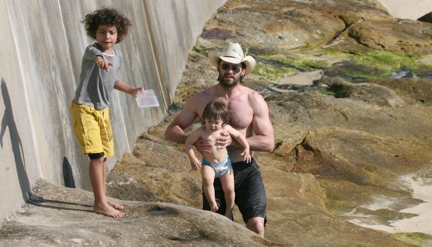 Hugh Jackman anda pelas pedras da praia de Bronte Beach, em Sydney, ao lado dos filhos Oscar e Ava, à procura de caranguejos (15/4/2007)