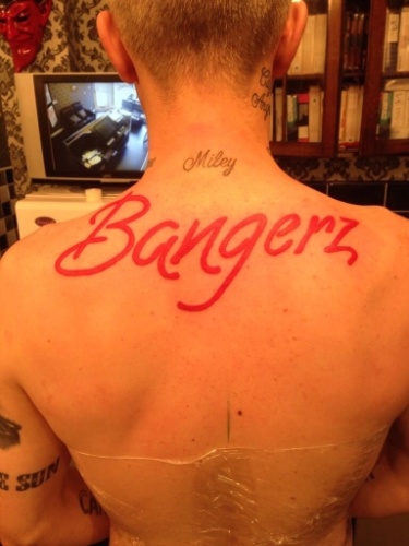Carl McCoid, 42, exibe tatuagens que fez em homenagem a Miley Cyrus. No alto das costas, ele tatuou o nome da cantora e o do álbum dela, "Bangerz"