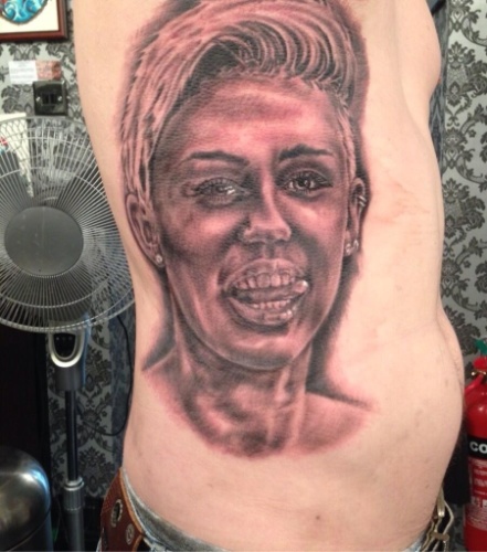 Fã de Miley Cyrus, Carl McCoid, 42, mostra tatuagem que fez do rosto da artista em suas costelas