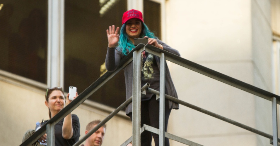 15.out.2013 - Demi Lovato acena se despedindo dos fãs em escada de emergência de seu hotel em São Paulo
