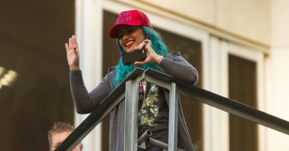 15.out.2013 - Demi Lovato acena se despedindo dos fãs em escada de emergência de seu hotel em São Paulo